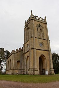 A stone church seen from the northwest, with a tower containing a porch in the foreground, and embattled body of the church stretching behind it