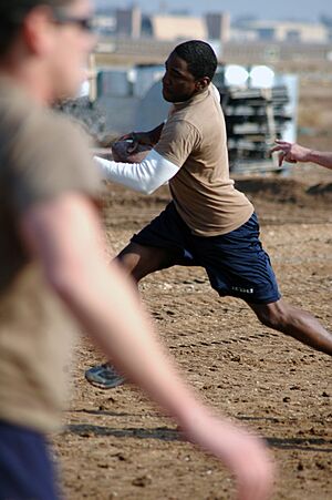 US Navy 080112-N-7367K-006 Builder 3rd Class Bryan Williams, assigned to Naval Mobile Construction Battalion (NMCB) 1, Task Force Sierra, scrambles out of a defender's reach in a two-hand-touch football game during the detachme