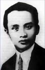 A young man, in a suit with a pale shirt and dark tie