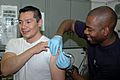 US Navy 091129-N-8960W-064 Hospital Corpsman Michael Parke gives a vaccine to Lt. Carlos Lopez aboard the aircraft carrier USS Nimitz (CVN 68)