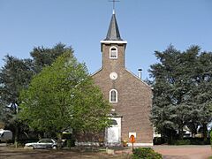 Religious building in brick with trees.