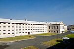 A large white prison building with many windows