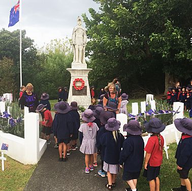 Pupils of the Matakana School placing their handpainted Remembrance Stones at the War Memorial