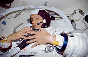 STS-31 Mission Specialist (MS) Sullivan dons EMU in Discovery's airlock
