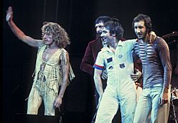 The Who onstage, standing and waving to a crowd