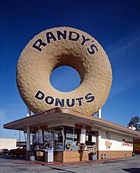 A picture of a Randy's Donuts location with donut sculpture on the roof.