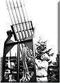 monochorome photograph of a man stood alongside of a device which comprises mainly a series of vertical pipes 