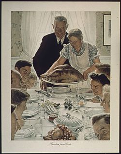 A large family gathered at a table for a holiday meal as the Turkey arrives at the table.