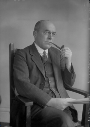 Middle-aged man in suit, with bald head and glasses