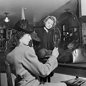 A customer tries on a new hat in the millinery department of Bourne and Hollingsworth on London's Oxford Street in 1942. D6596