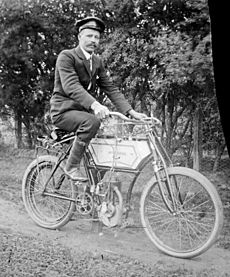 Man wearing cap & suit on motorised pushbike, Mt Buffalo Vic, Alice Manfield