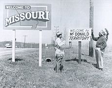 President McGowan and Cherokee Chief Henry Saugee displaying Welcome to McDonald Territory sign