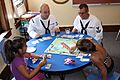 US Navy 110713-N-NT881-124 Personnel Specialist 2nd Class James Vail, left, and Boatswain's Mate 2nd Class Nathaniel Eaton play board games with ch