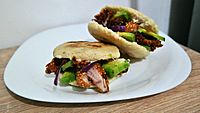 Arepas with chicken schnitzel, avocado, mayonnaise and red onion