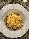 Spaghetti topped with chili, onions, and cheese
