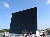 Large square black wall with people standing in front