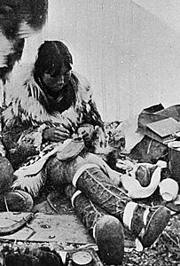 Eskimos drilling ivory and making mukluks, Port Clarence, Alaska, ca 1900 (HEGG 337) (cropped to mukluk-making)