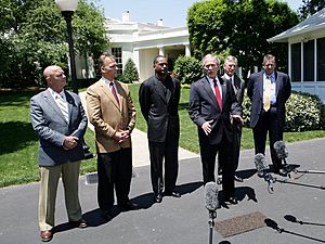 President George W. Bush speaks to reporters with NCAA head football coaches