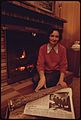 Women Uses Her Home Fireplace for Heat. A Newspaper Headline before Her Tells of the Community's Lack of Heating Oil 10-1973 (4271701391)