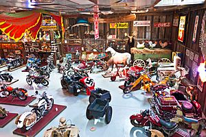 Large barn with motorbikes on pedestals, animal models, many metal signs.