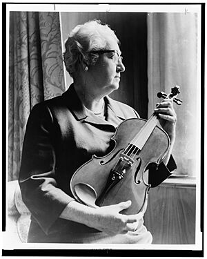 An expert on the violin, Dr. Apgar examines an instrument fashioned from an old telephone shelf. LCCN2002712241