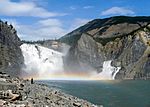 Large but relatively low waterfall through rocks.