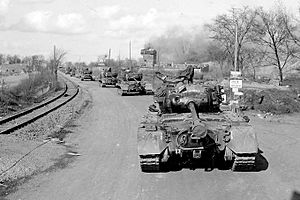 Convoy of Pershing tanks moves through a German town