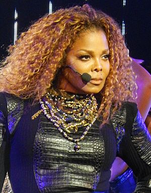 Janet Jackson with big curly hair looking to her left