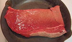 Beef round top round steak in pan, raw