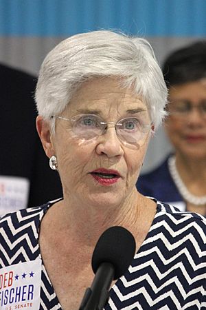 Woman with glasses, short gray or white hair
