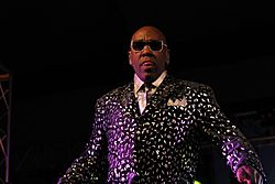 Wanz wearing sunglasses and a colorful suit