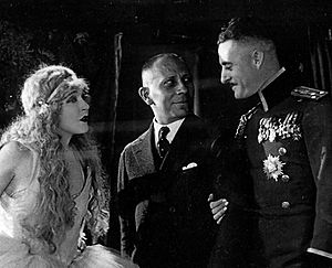 The Merry Widow (1925 film), directed by Erich von Stroheim, M-G-M studios. On set L to R, Mae Murray, von Stroheim, John Gilbert