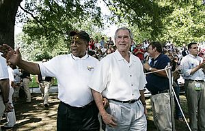 Baseball legend and hall of famer Willie Mays walks with President George W. Bush