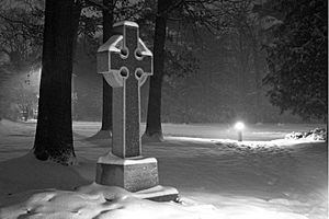 Celtic cross in snow storm at night
