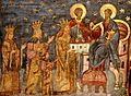 A bearded man who wears a crown offers a church to Christ who sits on a throne; the man is surrounded by a crowned woman and man and a child