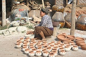 Woman glazing pots and NweNyein