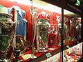 Four trophies inside a glass cabinet. The trophies have ribbons on them and there is memorabilia next to them