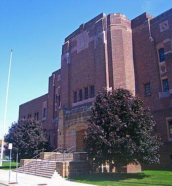 Front view of entrance and north wing of armory, a brown brick building in the Art Deco architectural style