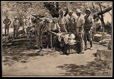 Boer War- Major B Forde RAMC bandages a wounded man at Paardeberg Drift. Wash drawing with gouache by H. M. Paget, c.1900 Based on a photo by Reinhold Thistle-Courtesy of Wellcome Collection