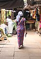 Walking woman with a fish in her hand Gambia