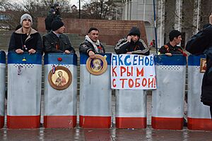 Отряд самообороны Крыма с щитами раскрашенными в цвета флага республики Крым охраняют памятник Ленина