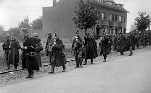Belgian soldiers taken prisoner by the Germans marching down a road