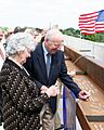 US Navy 090824-N-9876C-013 Retired Navy captain and former astronaut Jim Lovell and his wife, Marilyn Gerlach, sign the final roofing beam to be lifted into place during the topping off ceremony for the Captain James A. Lovell