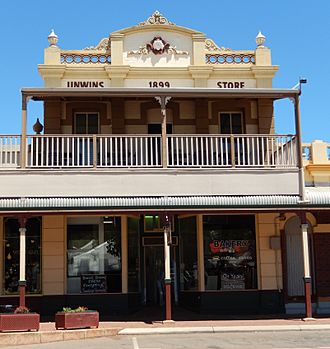 Photograph of the front of the building showing the balcony, verandah, and incorrectly-named façade.