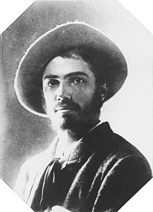 Black and white portrait photograph of Adolphe Appia in his twenties. He is dark haired and bearded and is wearing a hat with a big round brim.