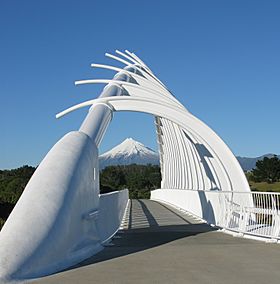View through the steel arch of a bridge, with a mountain in the background
