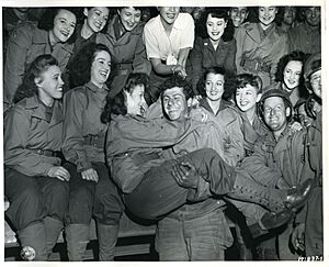 SC 191837-S - A GI gets an armful of beauty as a U.S.O. camp show puts on their first entertainment for American troops on the Continent (50064074473)