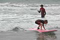 Surfing kid and adult