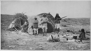 Apache rancheria with two men holding rifles - NARA - 530902