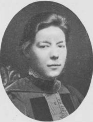 A yearbook photograph in an oval frame, of a white woman wearing an academic gown